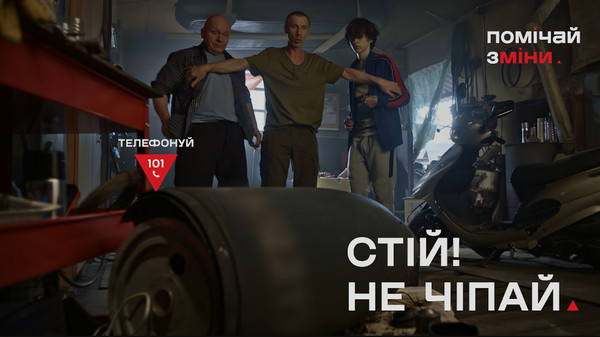 Соціальна реклама з мінної безпеки «Помічай зміни»: троє чоловіків у гаражі обережно зупиняють один одного перед підозрілим металевим предметом на підлозі. Написи: «Стій! Не чіпай» та «Телефонуй 101».