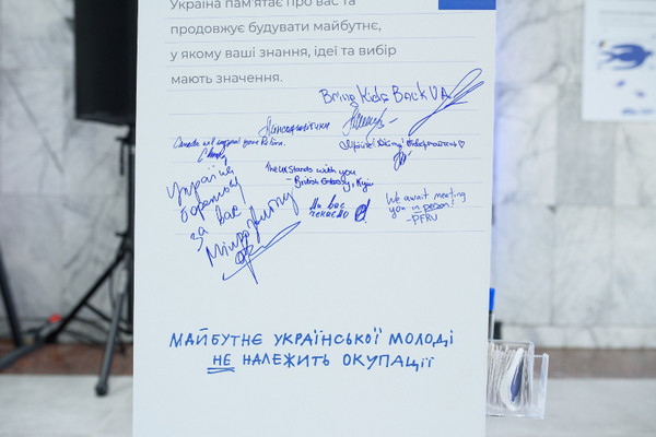 Стенд із написаними від руки побажаннями та підписами підтримки під гаслом «Майбутнє української молоді не належить окупації». 